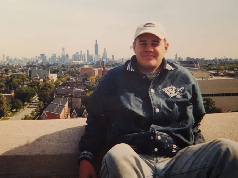 Saul Zenkevicius as a young man on a Chicago rooftop, the skyline behind him
